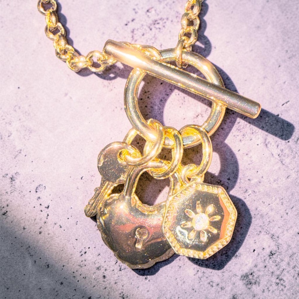 Gold Tone Long Chain Necklace with Heart Padlock Key and Sunburst Charms Toggle